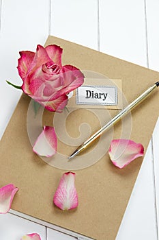 Diary with red rose and leaves