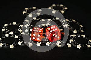 Dice and chips from winnings on the craps black table in the club. Fortune in the game depends on a successful combination in the photo