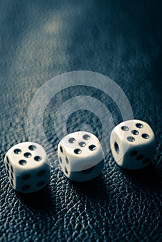 Dice with fives on a dark blue leather table