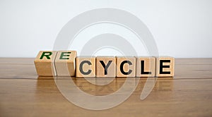 Dice form the word recycle on wooden table. Beautiful white background. Business and ecological concept, copy space