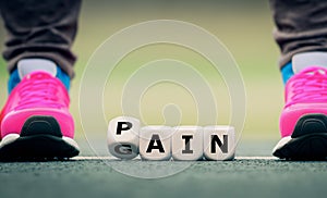 Dice form the words pain and gain. Symbol for the expression 'no pain no gain.