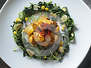 Dice fried tofu surrounded by spinach blanch