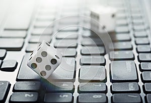 Dice on laptop computer keyboard. ÃÂ¡oncept of online gambling and online casino. Creative idea with devil`s bones and PC keyboard.