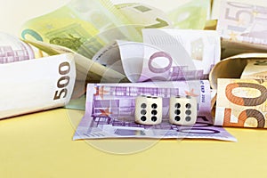 Dice and money. Two sixes on dice and euro banknote on yellow background. win, luck concept. Copy space. Selective focus