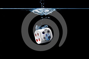 Dice with the numbers four and five faces in the water with black background