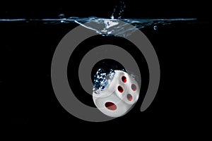 Dice with the numbers  one and four faces in the water with black background