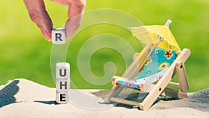 Dice placed next to a beach chair form the German word `ruhe` rest