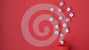 Dice on a Red Background Spilling From a Red Cup