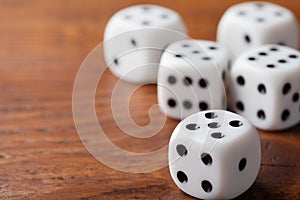 Dice on rustic wooden table. Gambling devices. Game of chance concept. Macro shot.