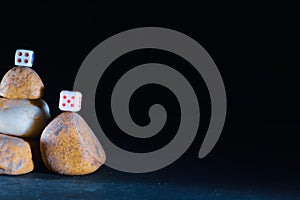 dice on stone Cairn and black backgrouund