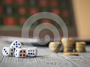 Dice on a wooden table with a notebook, pen and money. The concept of gambling online.