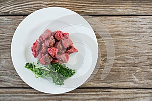 Diced beef and corainder leaves in white plate