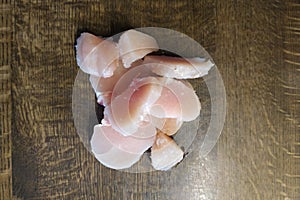 Diced chicken pieces of healthy lean white meat on a cutting board, filleted for cooking