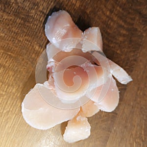 Diced chicken pieces of healthy lean white meat on a cutting board, filleted for cooking