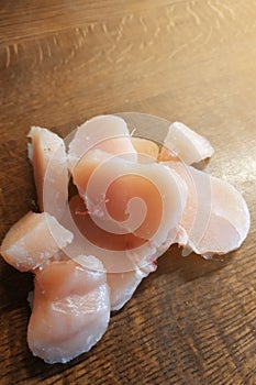 Diced chicken pieces of healthy lean white meat on a cutting board, filleted for cooking