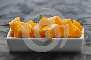 Diced mango cubes placed and served on a white dish closeup