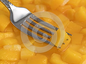 Diced mango on a forks tines