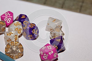 Dices for board games, dnd and rpg scattered on light surface