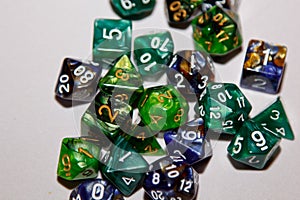 Dices for board games, dnd and rpg scattered on light surface
