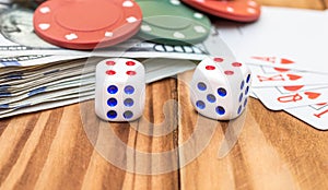 Dices with playing cards, poker chips and money on the wooden background. Close up