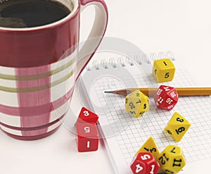 Dices for rpg, dnd or board games, notebook, pencil and a mug of coffee.