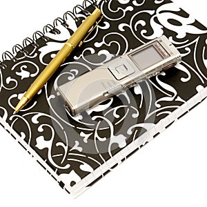 Dictaphone, notepad and ballpen on white