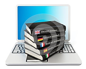 Dictionaries standing on laptop computer