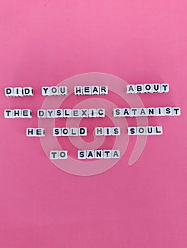 Did you hear about the dyslexic Satanist he sold his soul to Santa  funny Christmas poster on a pink background photo