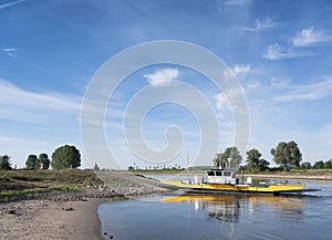 Yellow ferry on river ijssel between olburgen and dieren in gelderland photo
