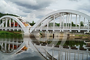 Diesel locomotive passing the Tha Chom Phu railway bridge or white bridge