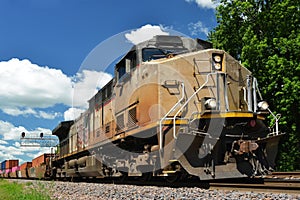 Diesel locomotive pulling a freight train of container cargo cars