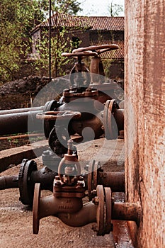 Diesel oil storage tank in an industrial plant. Open and closed valves.