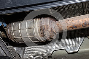 A diesel particulate filter in the exhaust system in a car on a lift in a car workshop, seen from below. photo