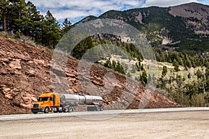 Diesel semi trailer truck on highway in rocky mountains