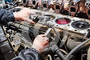 Diesel truck engine repair service. Automobile mechanic tightening using wrench