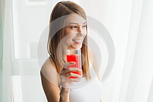 Diet. A beautiful young girl who follows the figure, drinking juice. The concept of healthy eating. White background