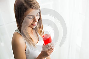 Diet. A beautiful young girl who follows the figure, drinking juice. The concept of healthy eating. White background