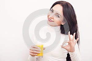 Diet. A beautiful young girl who follows the figure, drinking orange juice. The concept of healthy eating. White background.