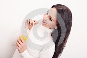 Diet. A beautiful young girl who follows the figure, drinking orange juice. The concept of healthy eating. White background.