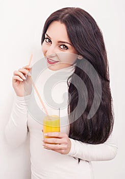 Diet. A beautiful young girl who follows the figure, drinking orange juice. The concept of healthy eating. White background.