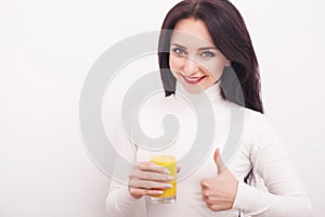 Diet. A beautiful young girl who follows the figure, drinking orange juice. The concept of healthy eating. White background.