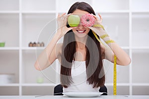 Diet. Beautiful Young Woman choosing between Fruits and Junk foo