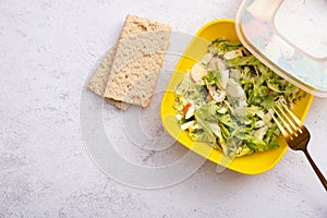Diet breads and salad of fresh vegetables and crab sticks in a plastic container. The concept of healthy eating