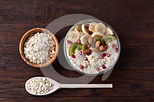 Diet breakfast oatmeal with fruits, bowl and spoon with oat flakes, selective focus, close-up