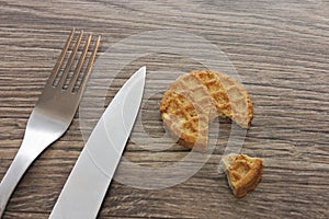 Diet cereal biscuit slice on dark wooden background with fork and knife photo