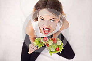 Diet. Cheerful woman eating vegetable salad.