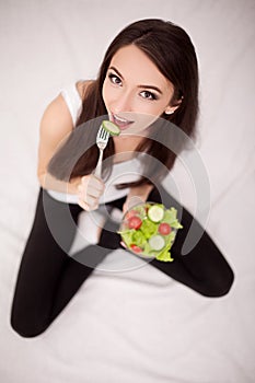 Diet. Cheerful woman eating vegetable salad.