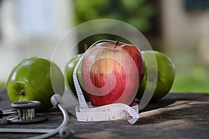 Diet concept apple red and green with tape measure.