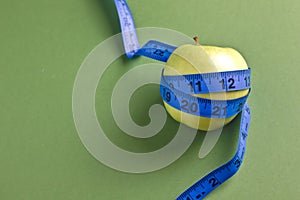 Diet concept, green apple with tape measure