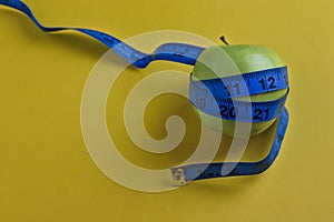 Diet concept, green apple with tape measure